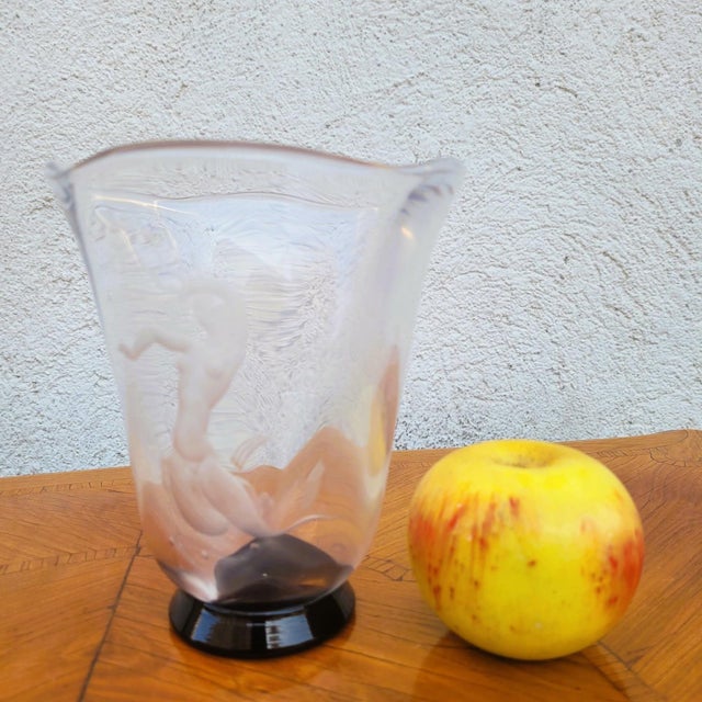 Clear glass vase engraved with a mermaid motif; the shape of the vase is reminiscent of sea waves. Vase on a black glass...