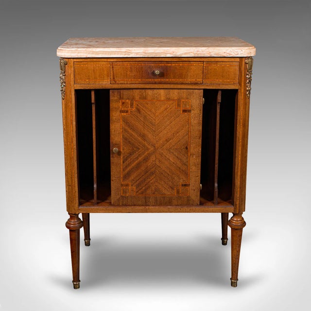 This is an antique bedside cabinet. A French, Kingwood and marble nightstand cupboard, dating to the late Victorian...