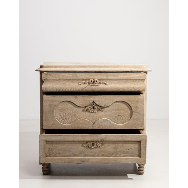 A solid oak chest of drawers reflecting traditional French craftsmanship with a focus on durability and function. The...