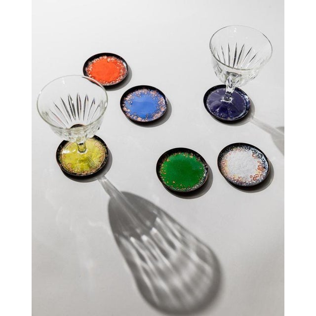 This vintage set of 6 enamel coasters from the 1960s is a vibrant example of high-quality craftsmanship and retro table...