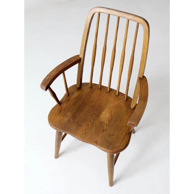 This is a Cochrane Furniture wooden arm chair circa mid-20th century . The Windsor style chair has modern styling with a...