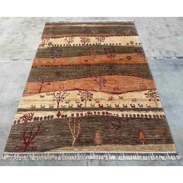 Description: Infuse your space with warmth and artistry through this Vintage Persian Gabbeh Wool Landscape Rug, a...