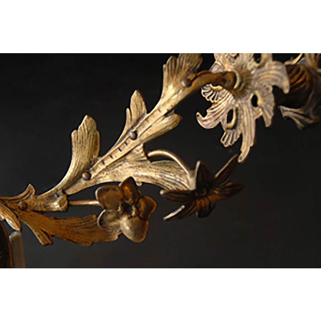 Circa 1900 two arm brass wall sconce. Traditional style with floral and foliate motifs.