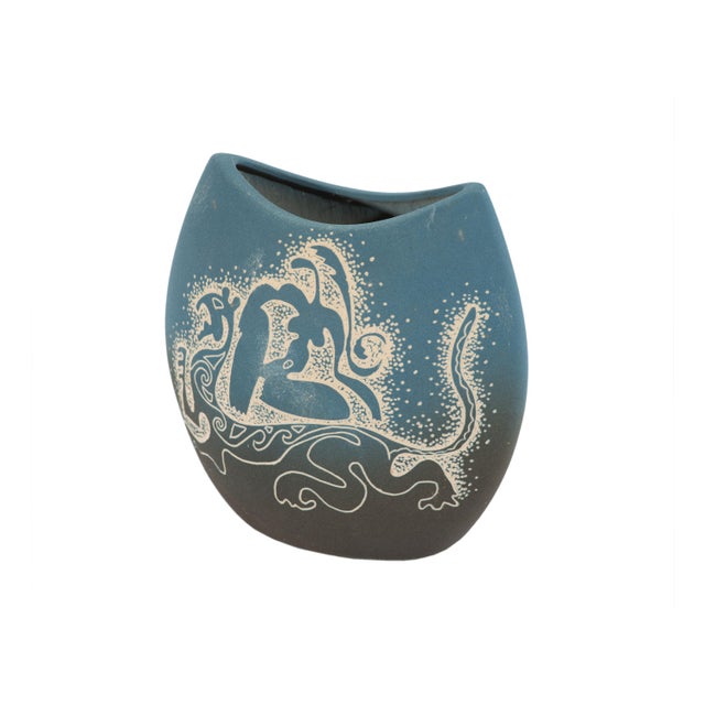 An oval-bodied ceramic vase. This vase features a blue ombre matte base glaze and sgraffito carving. Abstract...