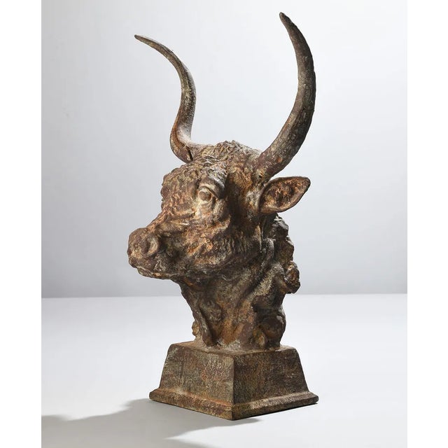A commanding cast iron bull sculpture with a weathered, time-earned patina that speaks to strength and endurance....