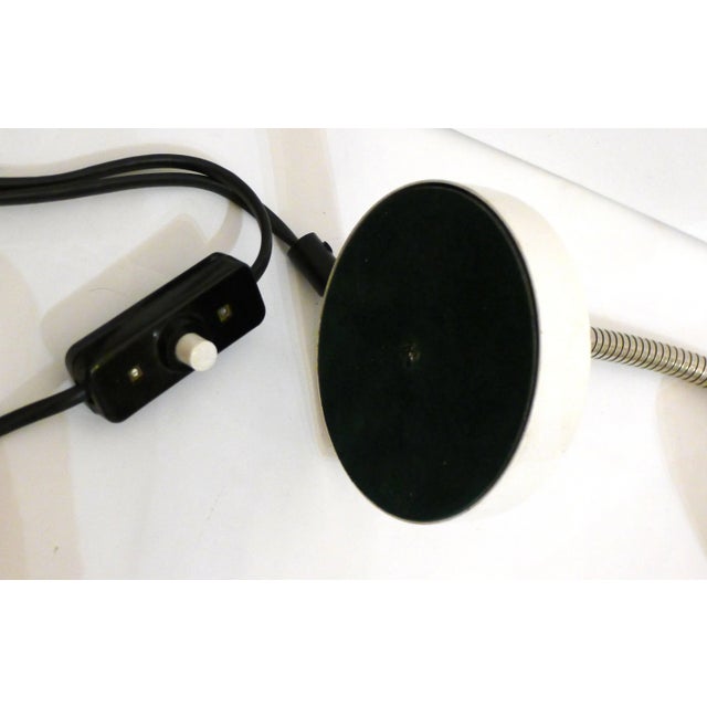 - Small desk lamp - In the shape of a spotlight - Comes with a flexible rod in chromed metal - Stands on a round base -...