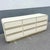 A sleek and sculptural Postmodern dresser showcasing a cream gloss laminate finish with softly rounded waterfall edges and...