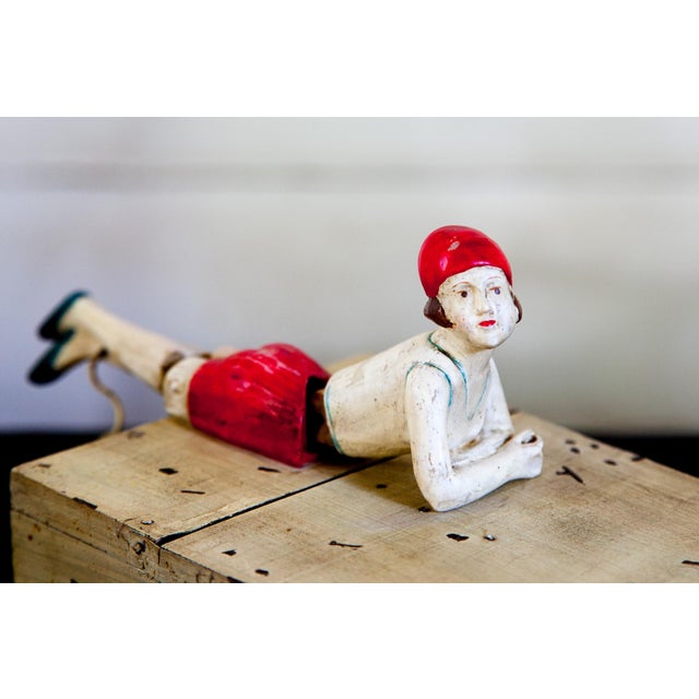 An ingenious box that lifts up with the help of a (possibly) Bakelite handle figurine. The early plastic "girl" in the...