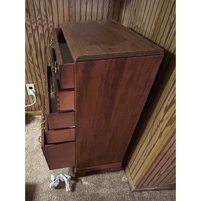 Solid wood, mahogany (dark auburn) chest of drawers with five drawers. Makers tag on inside top drawer. Made by Colonial...