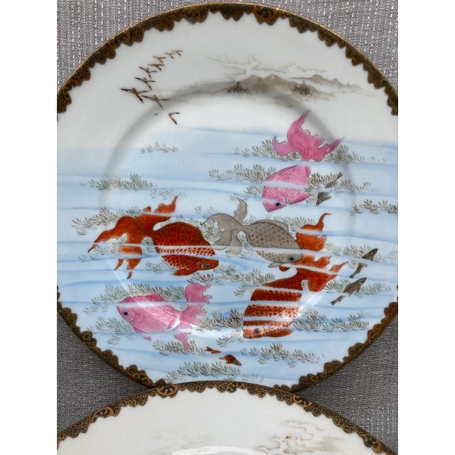 Antique set of hand painted Kutani dessert or salad plates, set of 9. Each has a different scene of Koi swimming under...