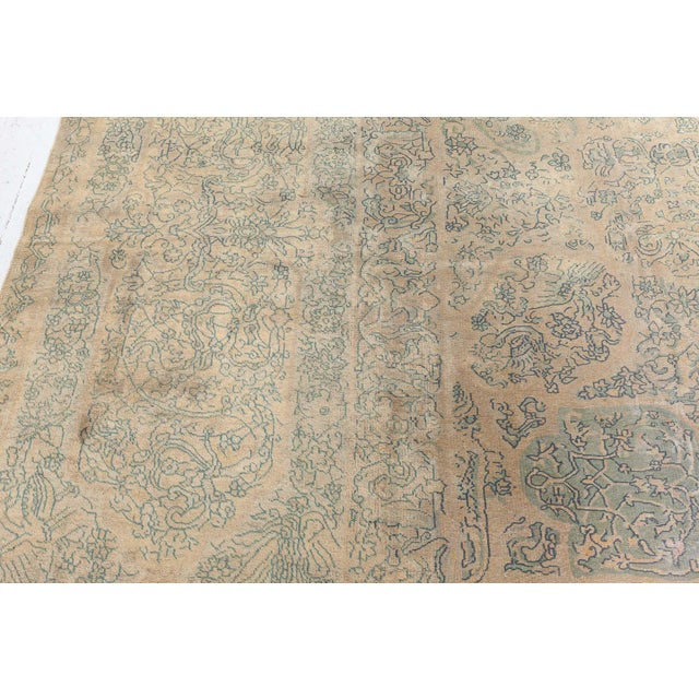 A late 19th century antique Indian rug having a tan field with an allover pattern of grouped floral motifs within a...