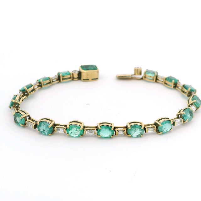 A refined 18 karat yellow gold bracelet set with sixteen richly saturated Colombian emeralds totaling approximately 8.15...