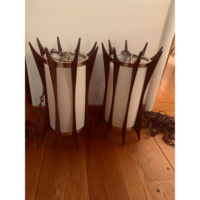 A rare and sculptural mid-century modern pair of pendant lamps. The lamps are unmarked and bear no designer label or...