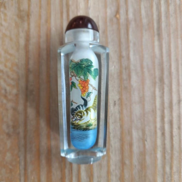 Imagine the patience required to paint two curious kittens through a neck no wider than a pencil. This vintage snuff...