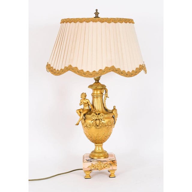 A superb and decorative Neoclassical Revival antique pair of ormolu urns, later wired into table lamps, dating from the...