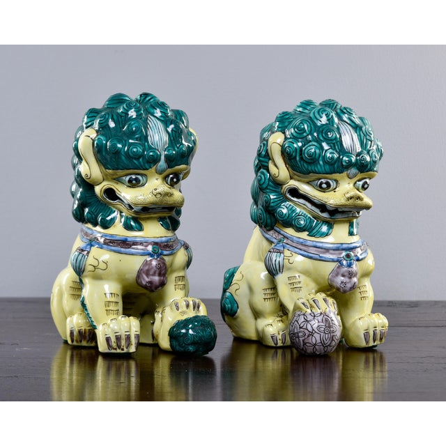 Acquired at a US estate sale, these porcelain Chinese foo dogs date from the 1960s. Dogs are glazed in green and yellow...