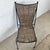 This vintage dining chair pairs a sculptural wrought iron frame with a handwoven reed seat and back, creating a striking...