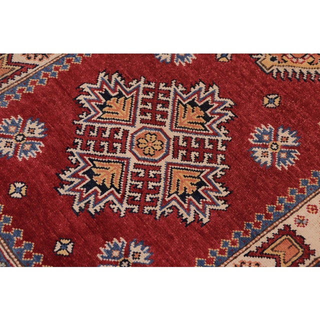 Enhance your home with this exquisite hand-knotted Super Kazak rug, crafted from fine hand-spun wool and dyed with all-...
