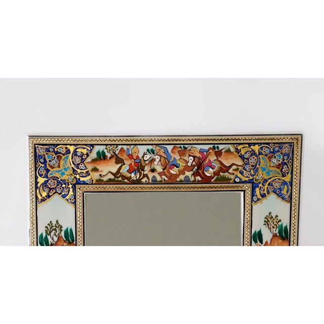 This hand-painted decorative mirror showcases a polo scene inspired by the rich tradition of Persian miniature painting....
