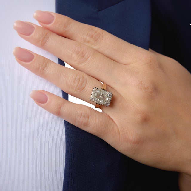 This delicate Edwardian ring showcases a charming arrangement of 12 old mine and rose cut diamonds totaling approximately...