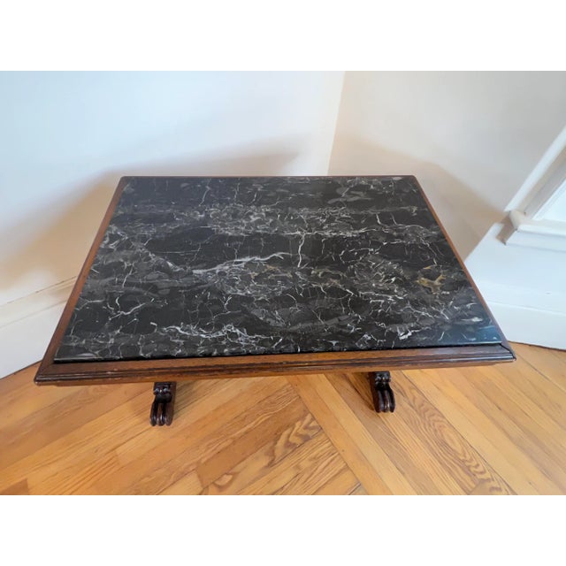 A beautifully decretive antique French Renaissance carved walnut side table with a marble top from the early 20th Century....