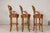 A set of three wooden swivel bar stools with carved backs. Elevate your home bar or kitchen island with this exceptional...