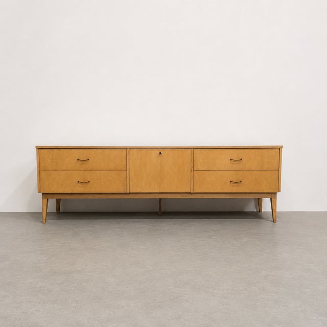 Elegant mid-century sideboard by Imexcotra, featuring a long, low silhouette and a sober architectural design. The...