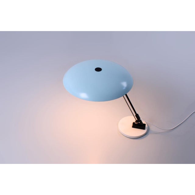 Striking minimal shaped metal table light. This elegant and quite large desk lamp displays the exemplary talent of the...