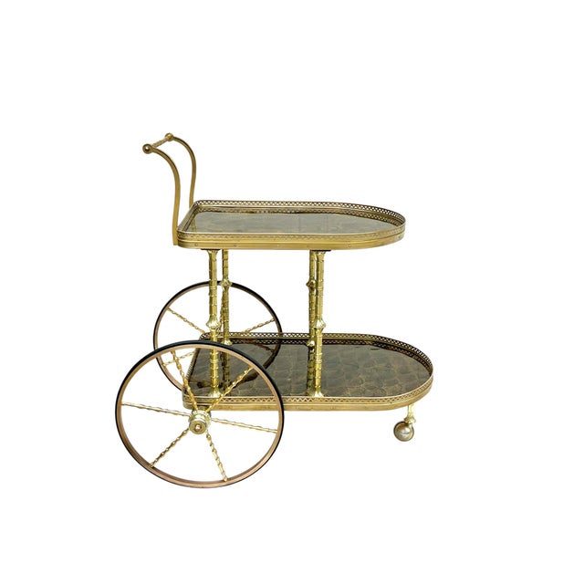 Elegant mid-century bar cart crafted in brass with richly patterned smoked tortoise-style resin shelves, designed in the...