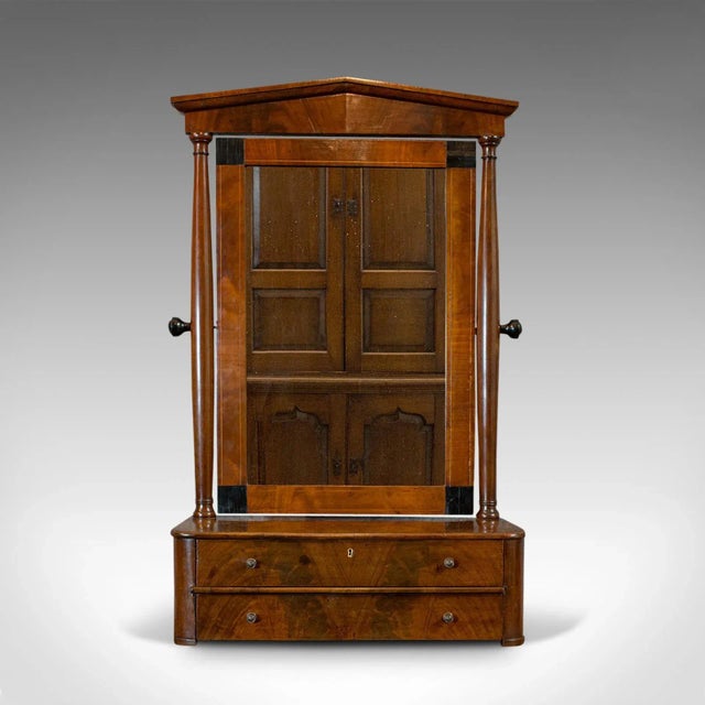 This is an antique toilet mirror. An English, walnut vanity mirror in Empire style, dating to the Victorian period, circa...