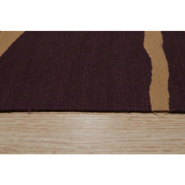 This purple wool rug features a flat weave construction and reflects the traditional style of Kilims. The primary color...