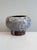 This hand-thrown ceramic vessel with a thick lava glaze in shades of blue on a brown background was crafted in the...
