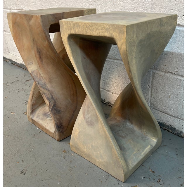 Make a bold, artistic statement with this striking pair of hand-carved sculptural wood side tables, where natural form...