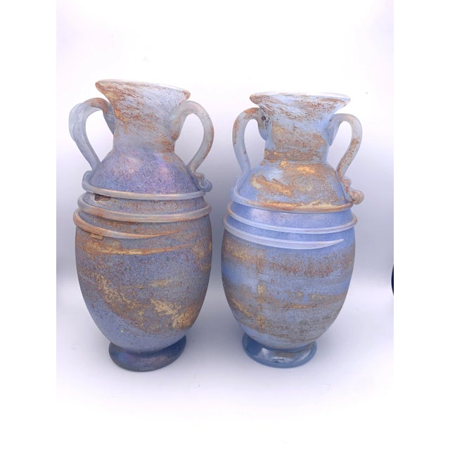 A matching pair of Murano glass vases with Roman-inspired amphora forms, flared mouths, applied loop handles, and glass...