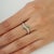 This elegant ring is crafted in 925 sterling silver, featuring a 0.22-carat round natural emerald complemented by 0.28...