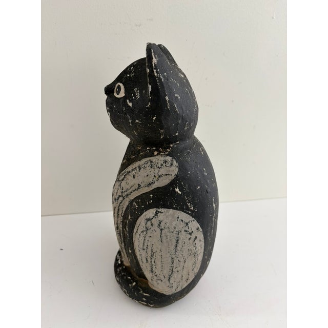 Vintage hand-carved wooden folk art cat with a simple, expressive face and bold black-and-white painted finish. This piece...