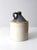 This antique stoneware crock jug features a brown slip top and a natural tone glazed base. Holding about two gallons, it...
