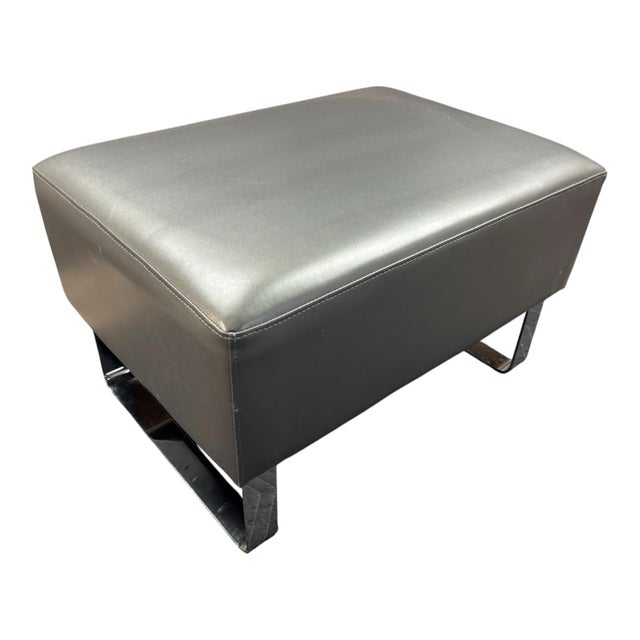The Gray leather Ottoman with Chrome Base is a modern and stylish addition to any living space. The ottoman features a...