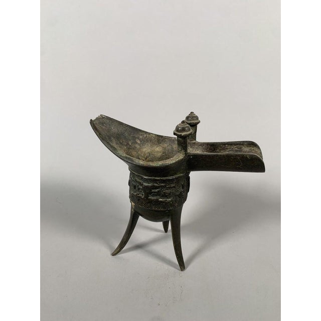 "Jue" tripod cup, China, Ming dynasty (1368-1644). This cup replicates the shape and motifs of the Jue ewers of the Shang...