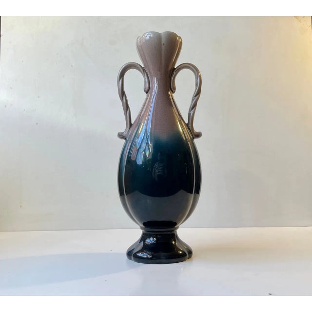 A tall handled porcelain vase in grey and dark petroleum blue craquele (intended small hairline cracks) glazes. Made at...