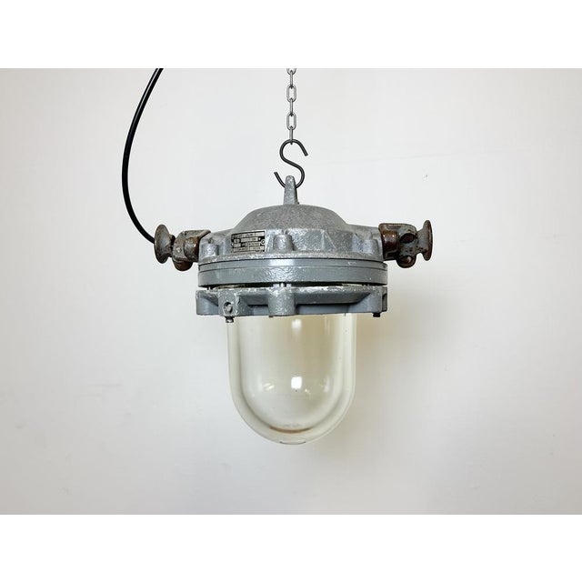 Dark grey industrial lamp with massive protective glass bulb made by Elektrosvit in former Czechoslovakia during the...