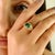 This exquisite ring is crafted in 18K yellow gold, featuring a 1.19-carat cushion-cut emerald as the centerpiece, bezel-...