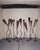 A collection of twelve vintage sculptural metal candlesticks featuring elongated adjustable stems, tapered cone tops, and...