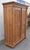This large two door armoire has a rich warm color and a strong grain pattern. The impressive crown sits above a plain...