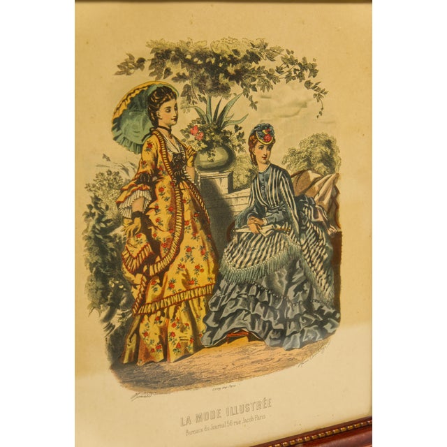 A pair of framed fashion illustrations from La Mode Illustrée magazine. Matching carved wooden frames with clear glass....