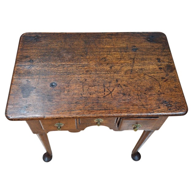 18th century queen anne three drawer oak lowboy with turned legs and pad feet. Later brass drawer pulls. 27" W x 17" D x...
