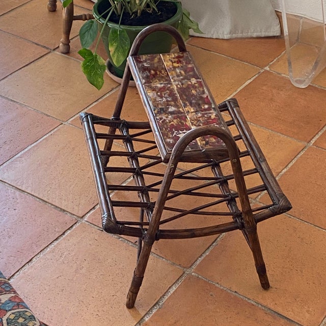 Rattan magazine rack with ceramic shelf. A 1970s model, featuring a free-form design. The magazine rack features a...