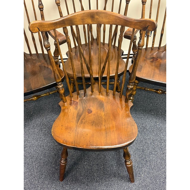 A handsome set of four Ethan Allen Windsor-style dining chairs, consisting of two armchairs and two side chairs. Crafted...