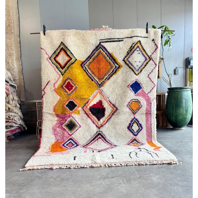 This Moroccan rug features a captivating color palette, showcasing a unique and intricate geometric pattern. The design...
