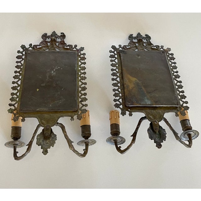 Pair of Napoleon III style bronze sconces. Bevelled mirror, two branches of lights. The bronze is worked and decorated...